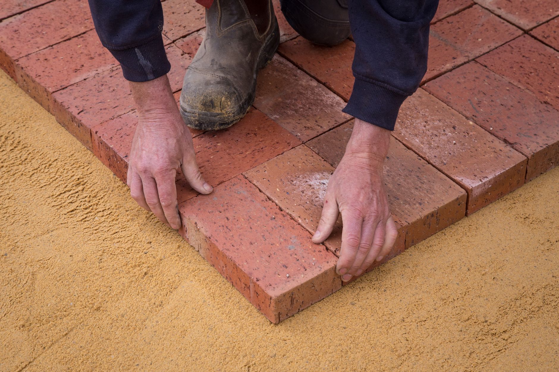 Pavers being laid on a sand bed